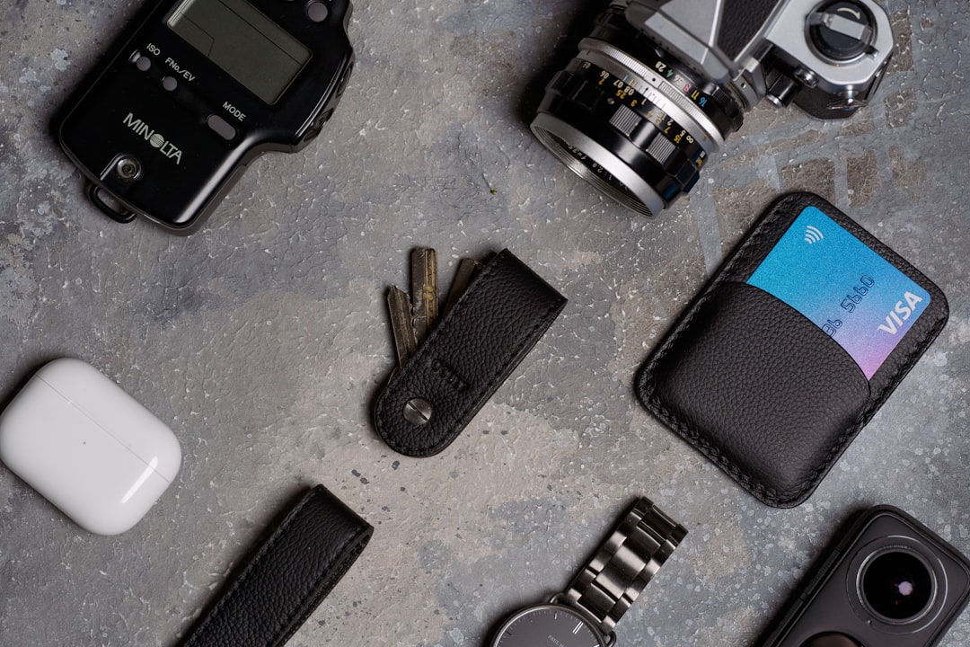 Editorial cover showing everyday carry accessories laid out neatly: slim wallet, keys, watch, sunglasses, belt, compact bag, and pen, arranged on a neutral surface